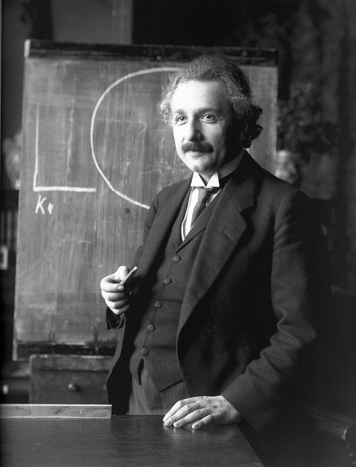 The original black and white portrait of Albert Einstein in front of a blackboard, 1921.