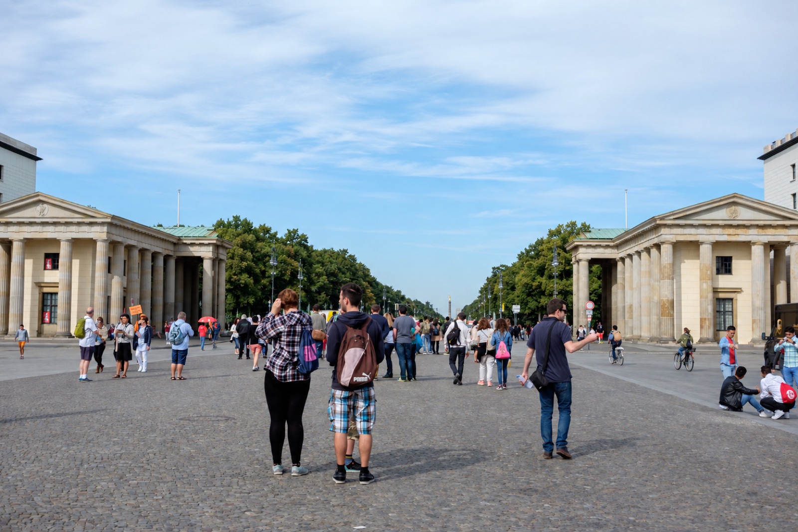 The same Berlin avenue without the gate: a wide paved street lined with trees and lamp posts leading to the Victory Column in the distance.